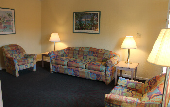 The living room includes a flat screen TV, a desk and a desk chair