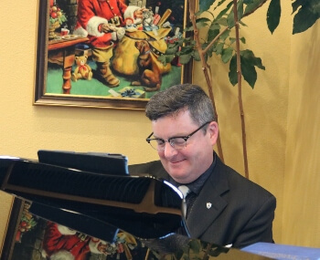 Dr. Eric J. Littleton plays carols on the Grand piano in Pigeon Forge