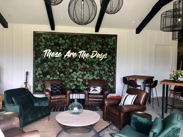 Leather chairs, living plant wall and table complete the indoor/outdoor living room in the backyard barn.