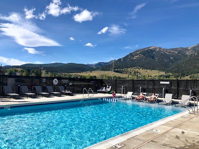 Wilson hotel outdoor pool shallow end. Wilson Peak views with blue sky behind the swimming pool.with two ladies in lounge chairs, resting in the pool