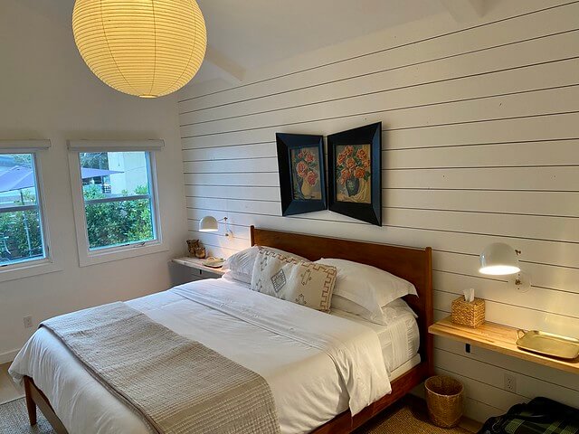 King size bed with white bedding and picture window at Bungalow B in Calistoga. 