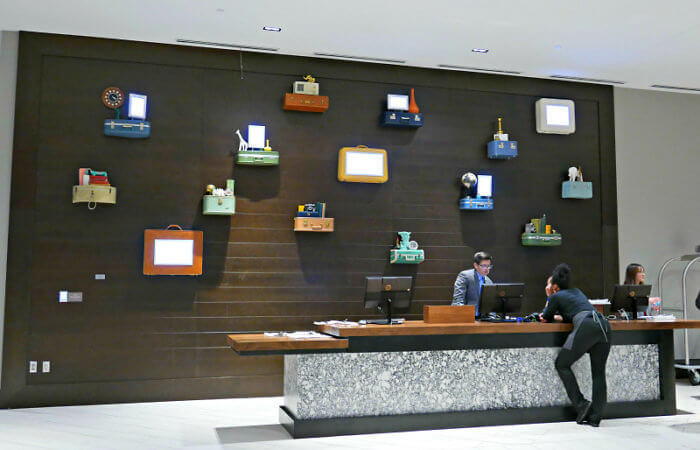 Integrated art includes a luggage wall behind the reception desk at Hyatt Place Pena Station. Photo: Diana Rowe