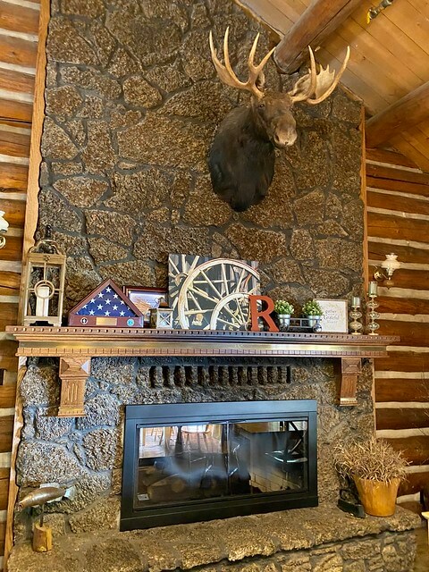 Floor to ceiling fireplace with mounted moose head in the main lodge at Red Horse Mountain Ranch. 