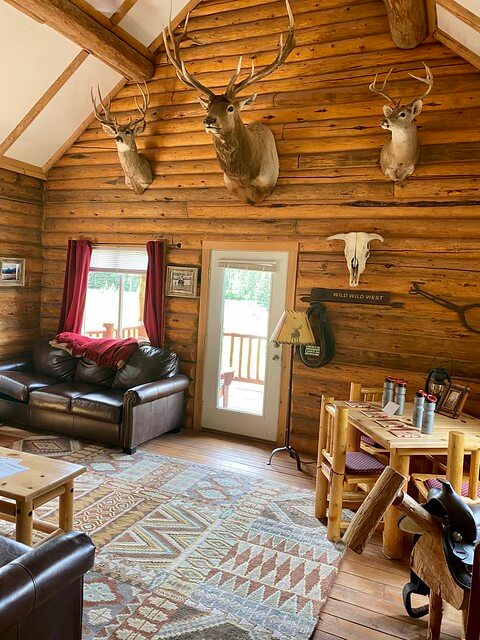 Eagle's Nest log cabin includes mounted deer and elk heads, leather furniture and Western style rugs. 