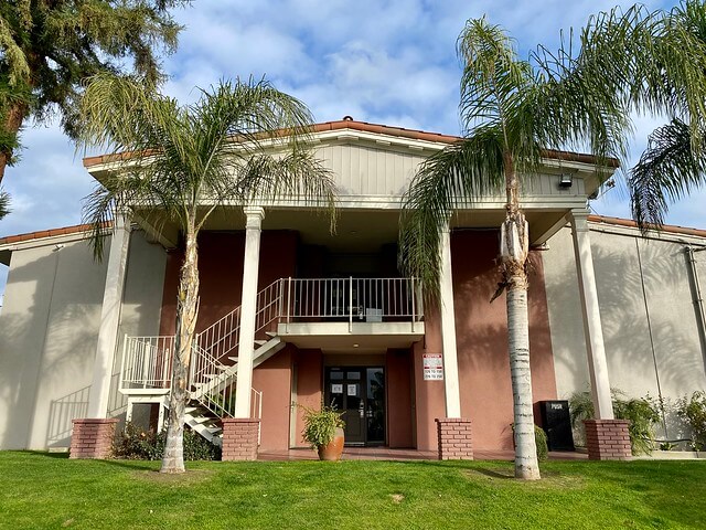 Best Western Hill House entrance with palm trees and grass 