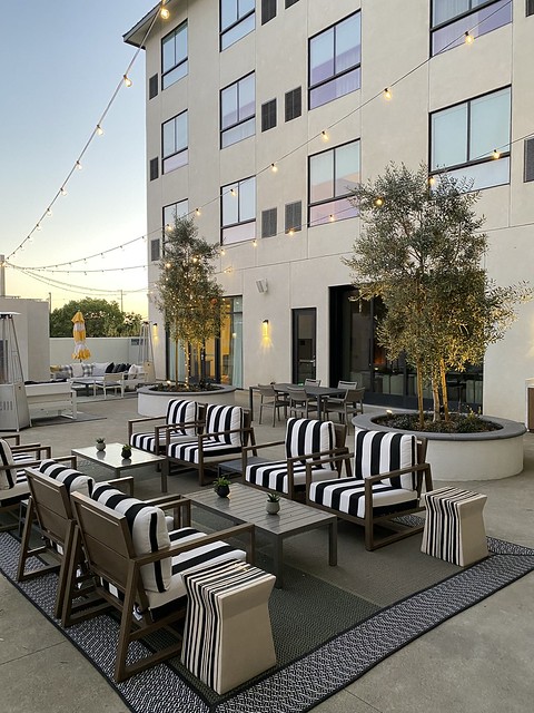 Outdoor patio with white lights and places to gather at Cambria Hotel Napa Valley. 