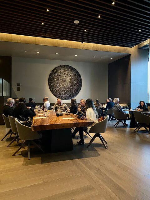 Communal wood slab dining table at Adrestia restaurant inside the hotel.