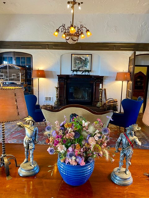 Benbow Inn fireplace with fresh flowers on the table that holds newspapers and reading materials. 