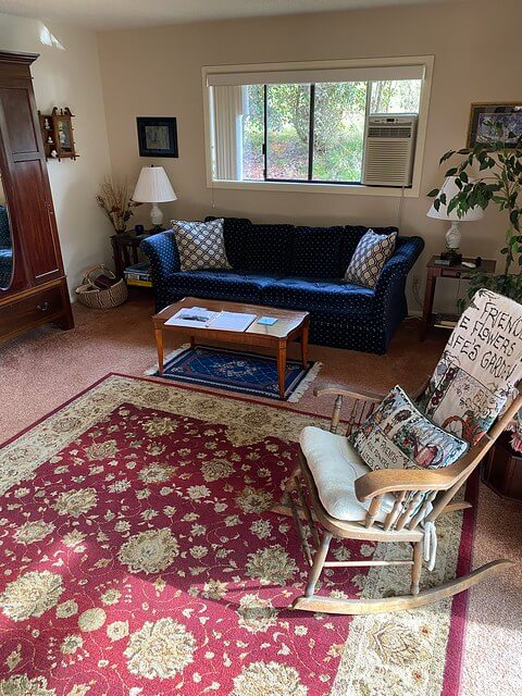 Living room with oriental rug, blue sofa and rocking chair are yours to use during your stay in Roseburg, Oregon.