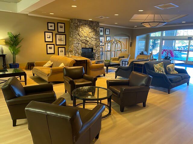 Dark leather chairs, beige leather sofas, back to back, by the rock fireplace in this Petaluma Sheraton hotel lobby. 