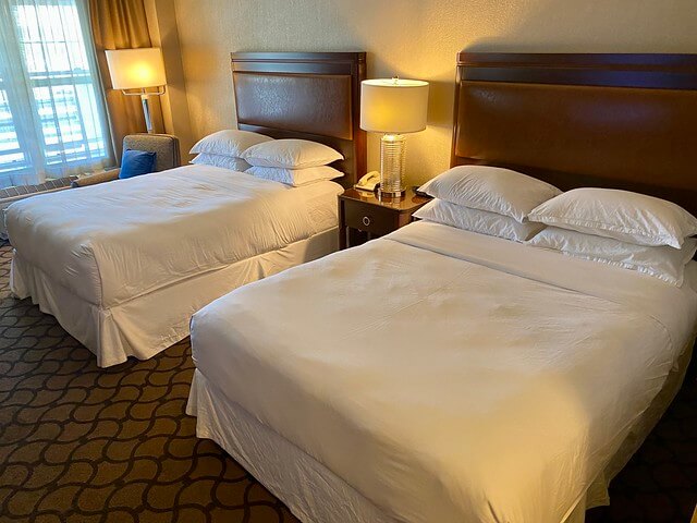 Sheraton Petaluma hotel room with 2 queen beds, 4 pillows on each bed, in addition to headboard and lamp on each nightstand. 