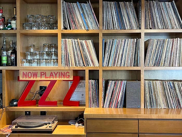 shelves filled with albums sit behind a turntable