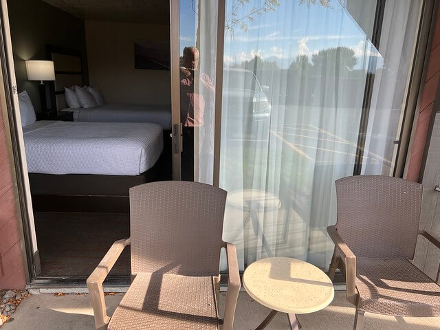 The 2-story Best Western hotel featured a small patio with two beige chairs and a small, circular cream-colored table. 