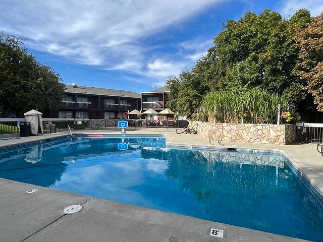 Outdoor swimming pool with cement patio at Baker City Best Western Sunridge in Oregon.