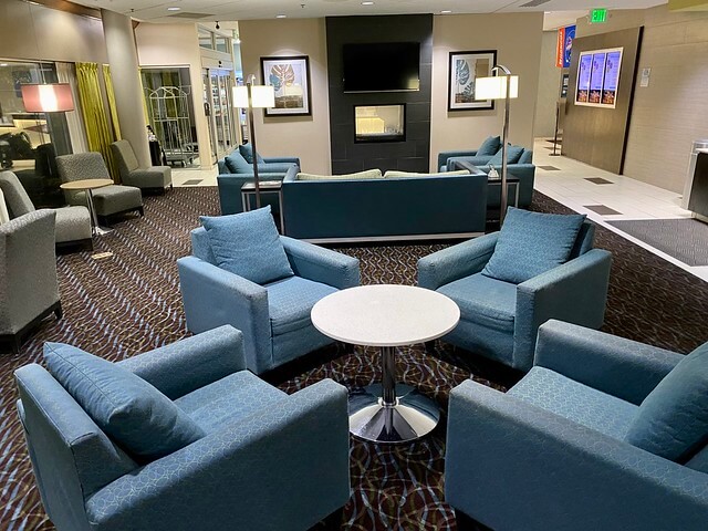 Holiday Inn Express Boise hotel lobby with blue chairs, a gas fireplace is beyond. 