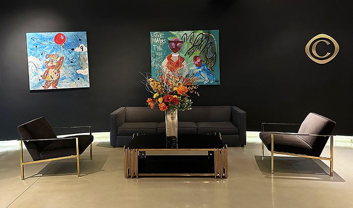 Black walls are accented with colorful paintings in the Cachet Boutique lobby