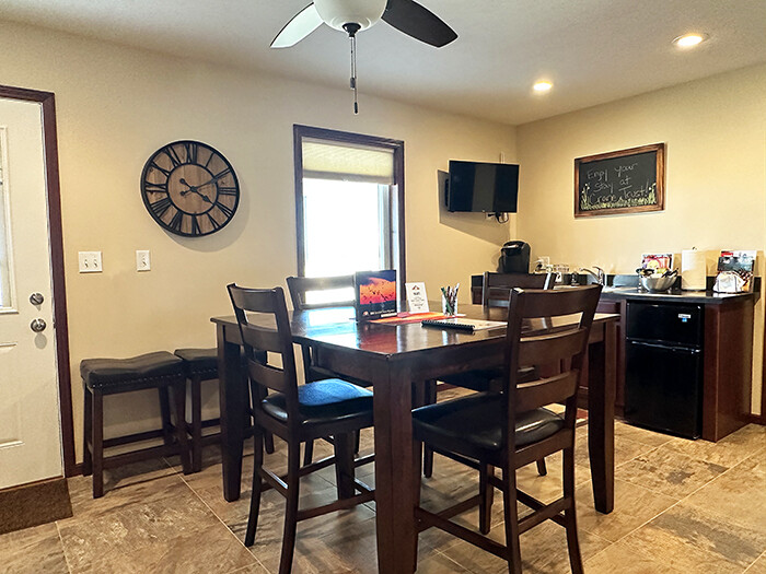 A small kitchenette with a bar-height wood table and chairs