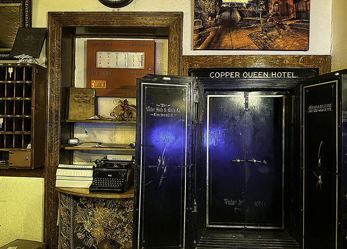 A vintage safe and key rack line the wall behind the check-in counter