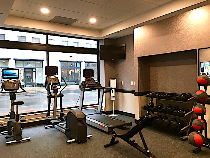 Main floor fitness room with treadmill, stationary bike and more.