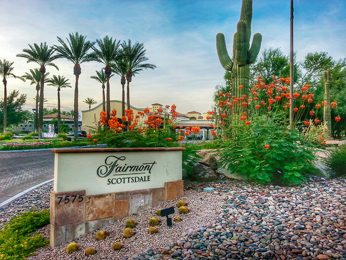 Entry drive to Fairmont Scottsdale Princess with signage, palm trees and saguaros