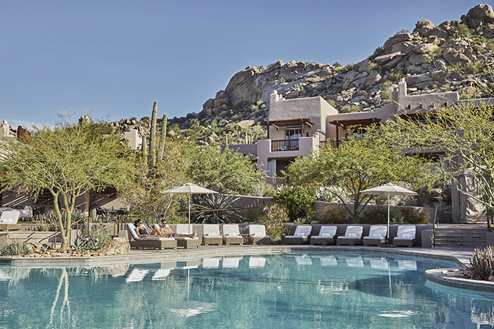 View from pool to Puebo-style buildings of Four Seasons with rocky mountain cliffs in background