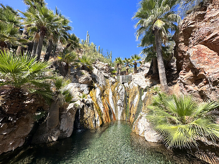 Water pours from rocks into crystal blue pools