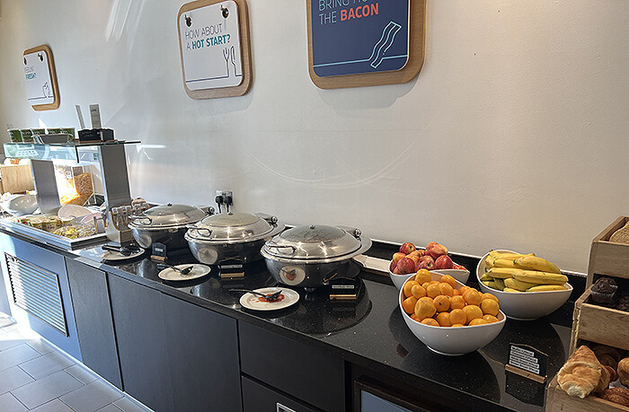 Breakfast buffet counter with hot plates, fruit