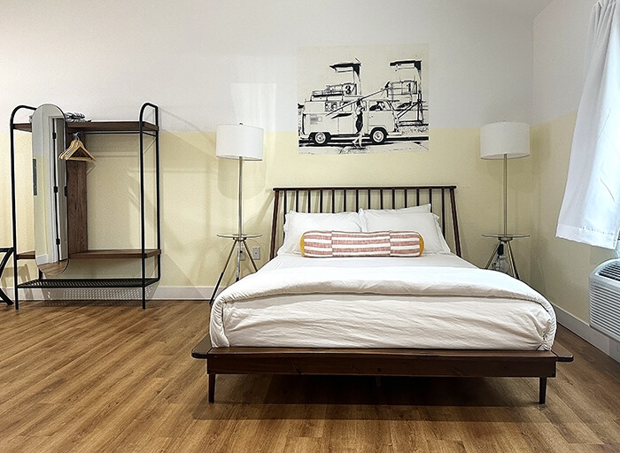 Guest room with minimalist furnishings, plush bedding and custom art.