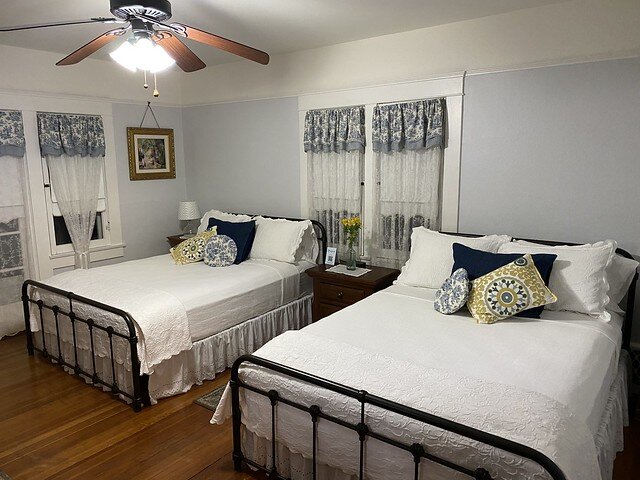 Two queen beds with white bedspreads in Lady Ann room