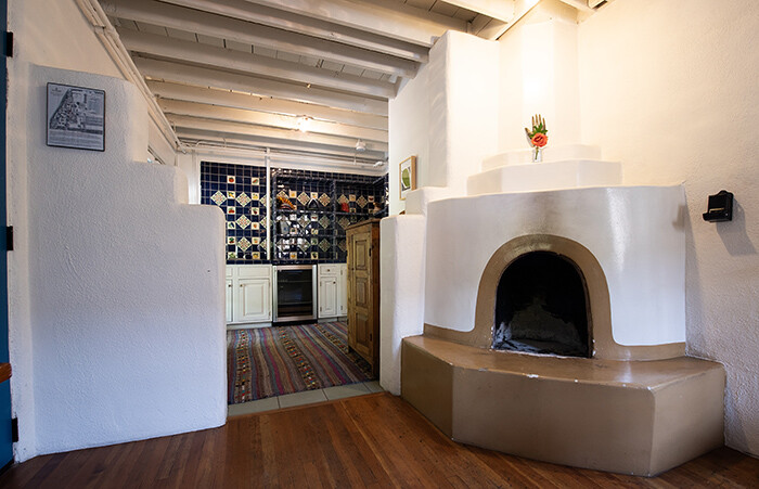 Kiva fireplace, wood furnishings, Pueblo architecture and tiled kitchen of the Meem Suites