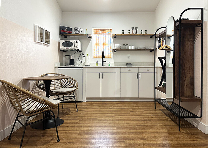 White kitchenette with open shelves in guest room