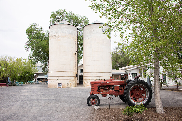 Grain silos and a red tractor show that Los Poblanos is a working farm.