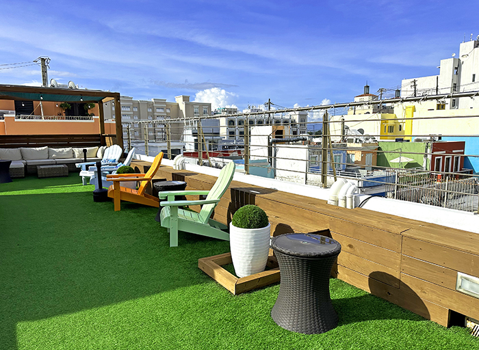 Rooftop sitting area with turf and colorful chairs