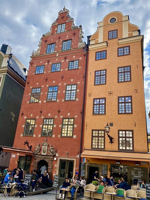 Two red and terracotta orange buildings stand side-by-side in Stortorget Square, Stockholm, Sweden