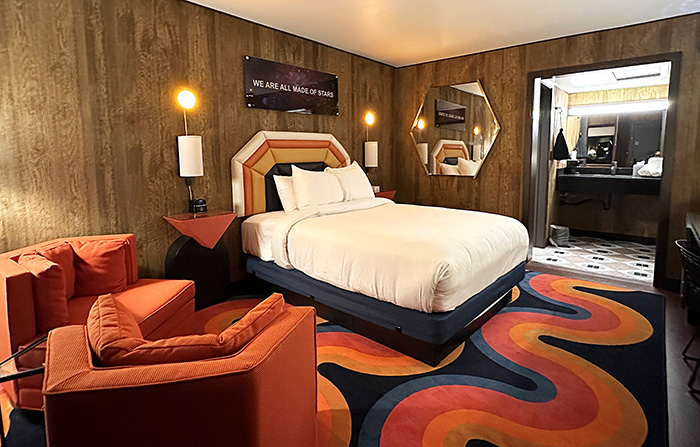 Guests rooms feature wood paneling, graphic area rugs, and padded headboards inspired by vintage ski wear.