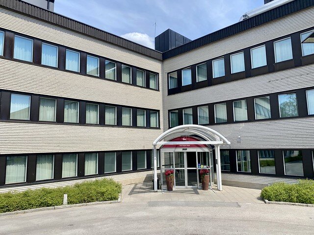 Best Western Plus Park Airport Hotel entrance. Three-story Airport Hotel comes together in a v-shape with a small, white metal portico entrance. 