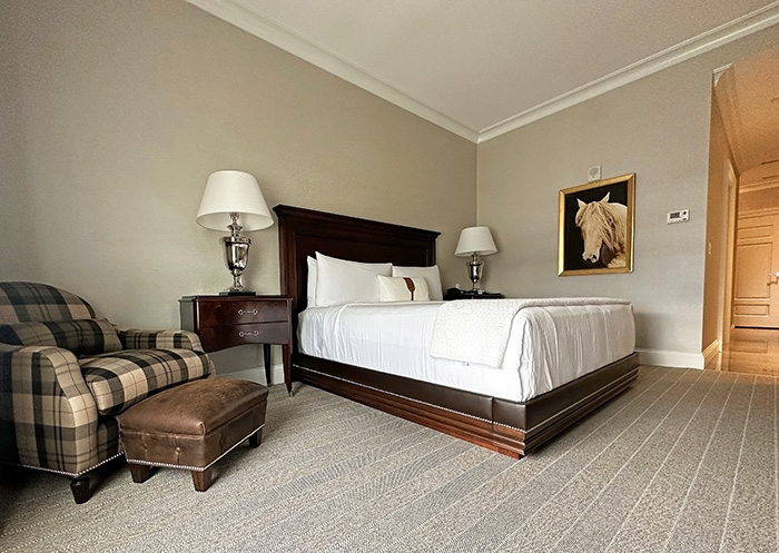 The rooms at the Equestrian Hotel feature neutral hues, wood and leather furnishings, and crisp white linens.