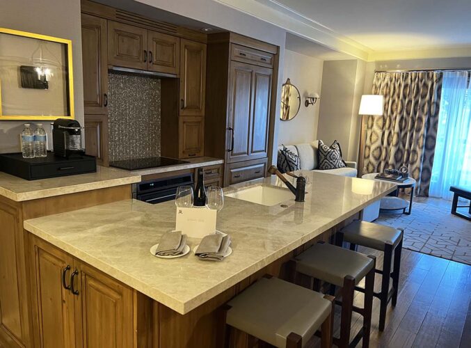 Hotel room with marble counter, bar chairs, coffeemaker.