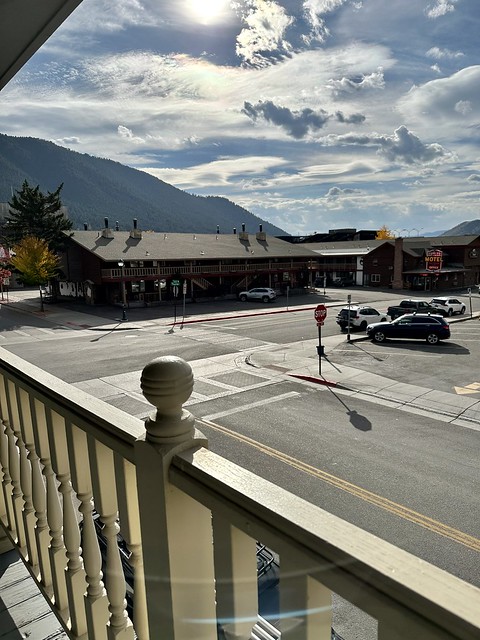 The Antler Motel is across from our Ranch Inn motel room. Our wood balcony railing is seen from our room, with the Wyoming blue sky, filled with white, puffy clouds. 