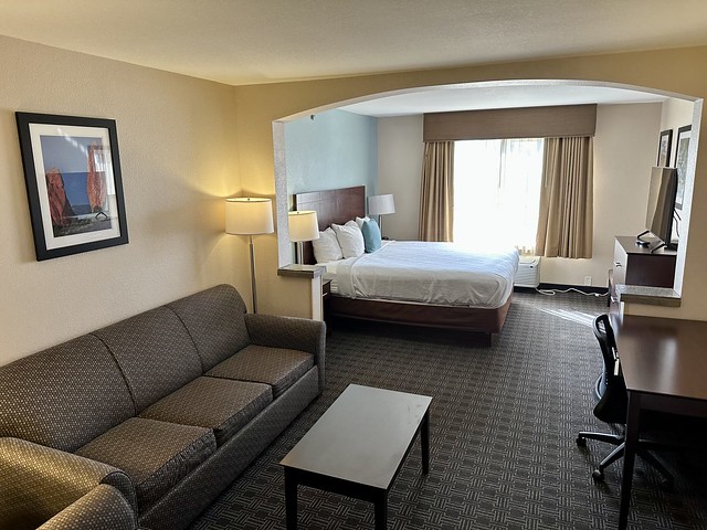 King suite with brown-patterned sofa bed, coffee table and king bed beyond couch. 