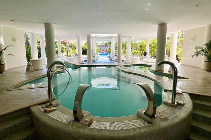 Round pool with water sprays at Excellence Riviera Cancun open-air spa.