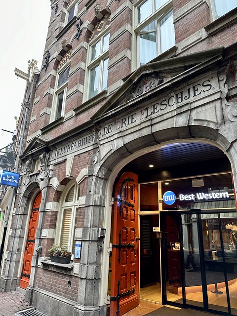 Best Western Dam Square Inn exterior with De Drie Fleschjes engraved lettering above the entrance to the historic Amsterdam hotel. 