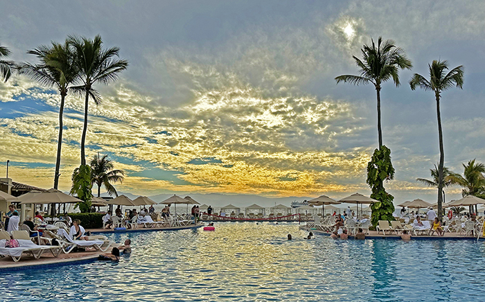 A sunset view of the ocean from a swimming pool