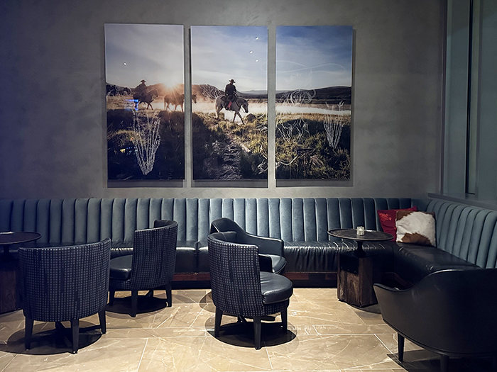 A photographic triptych featuring cowboys on horseback overlooks a quite corner seating area at Renaissance Dallas Plano 