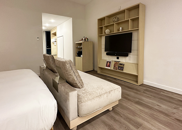 A guest room at the Gabriel Miami features minimalist furnishings and a padded TV cabinet.