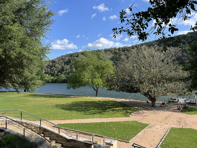 Grassy area with sandy walkways on a river