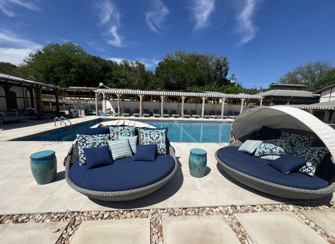 Clamshell-like comfy seating on an outdoor pool deck under blue skies