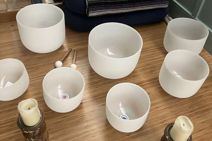 Sound bowls and candles grouped together on the floor.