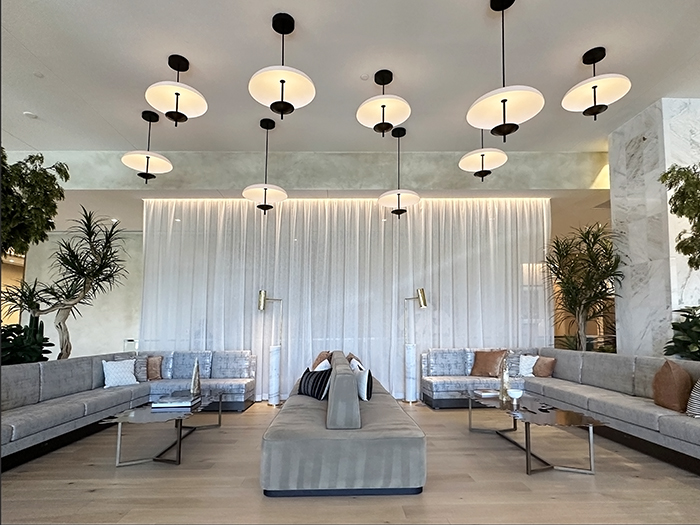 A luxe seating area with plush gray setting and dramatic light fixtures in the lobby of Caesars Republic