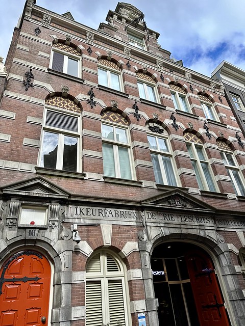 Exterior of the brick, 3-story Best Western Dam Square Inn hotel. Two rows of 5 glass windows rise above the bright red hotel front door. 